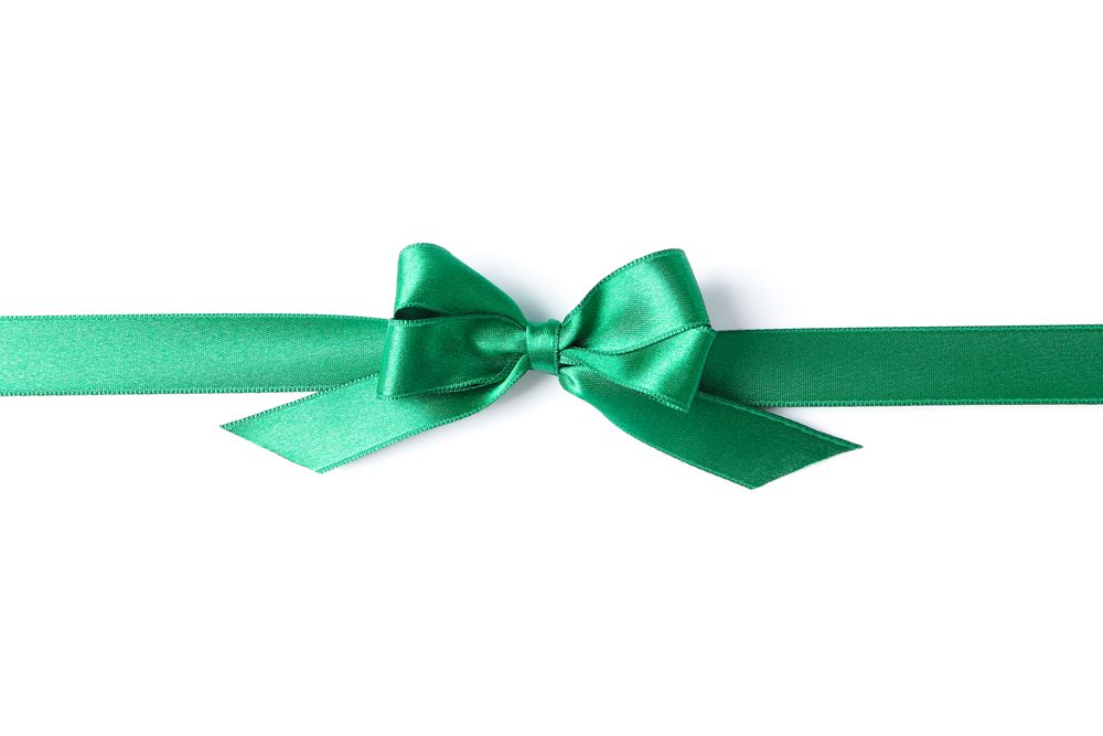 Green ribbon with bow isolated on plain background. Gift concept