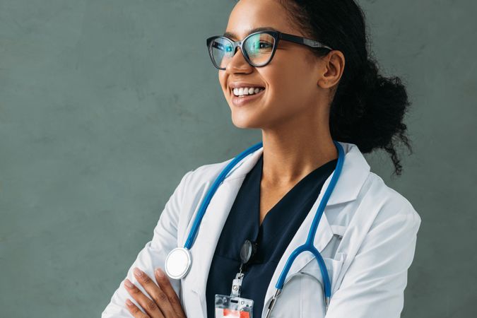 Side view of smiling Black doctor in lab coat and stethoscope