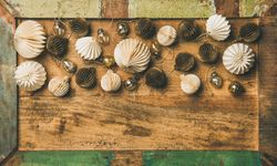 Gold and cream folded tree ornaments, and baubles on wooden counter, copy space
