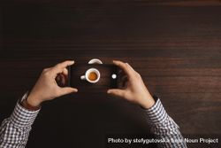 Top view of man wearing plaid shirt taking picture of espresso shot with cell phone 5k19Lb