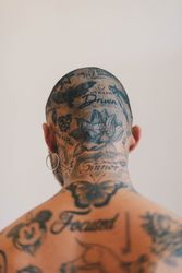 Close-up of tattoos on back of neck of young shaved-head man