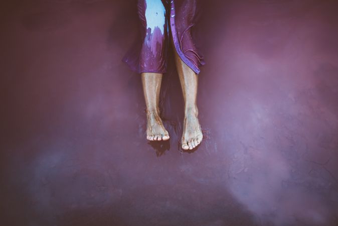 Legs of woman sitting in sea water