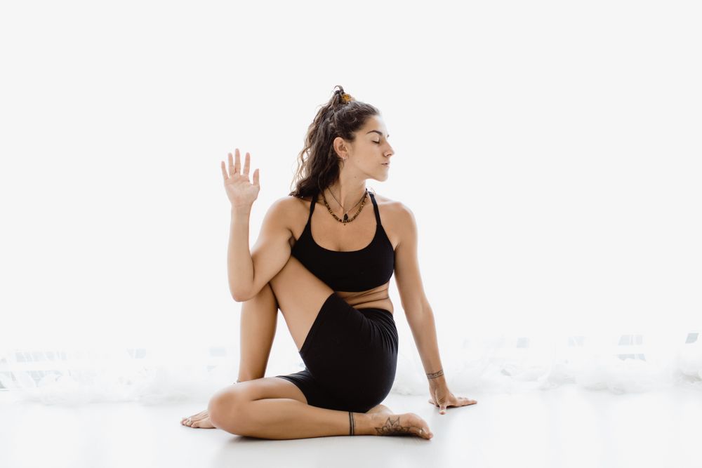 Sportive woman performing yoga pose in room