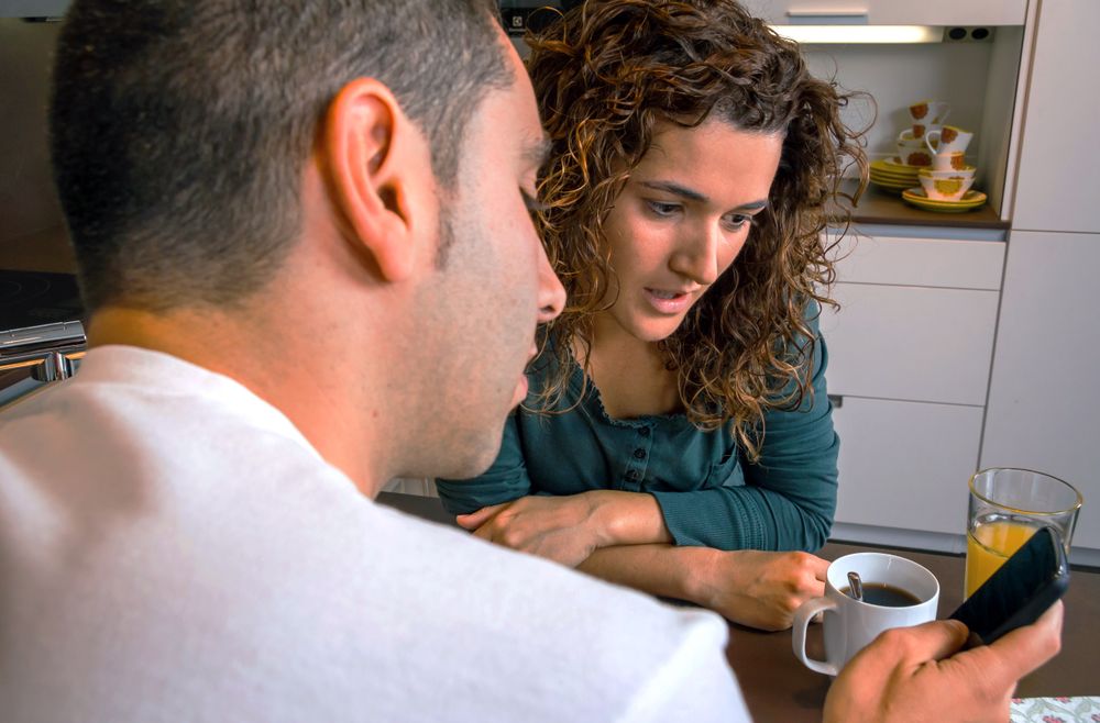 Couple looking at phone screen at breakfast