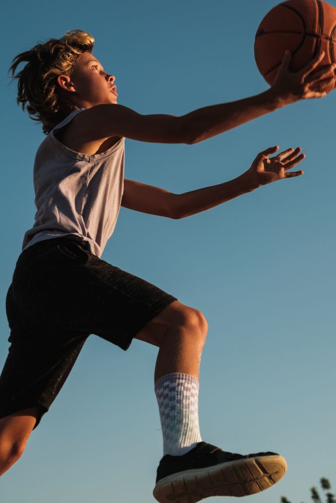 Active boy throwing basketball in hoop