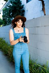Female photographer in denim looking back through photos on a digital SLR