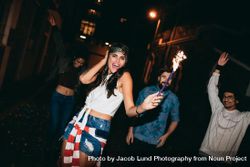 Young friends partying with sparklers on 4th of july 0JdBd4