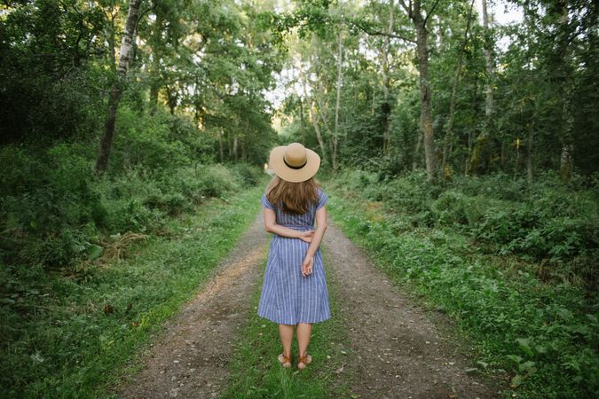 Young woman standing among pine trees
