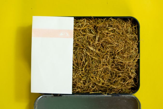 Top view of box of loose leaf tobacco with rolling papers