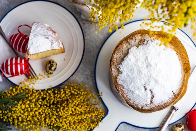 Top view of Easter food concept with traditional cake and colorful eggs decorated with yellow spring flowers