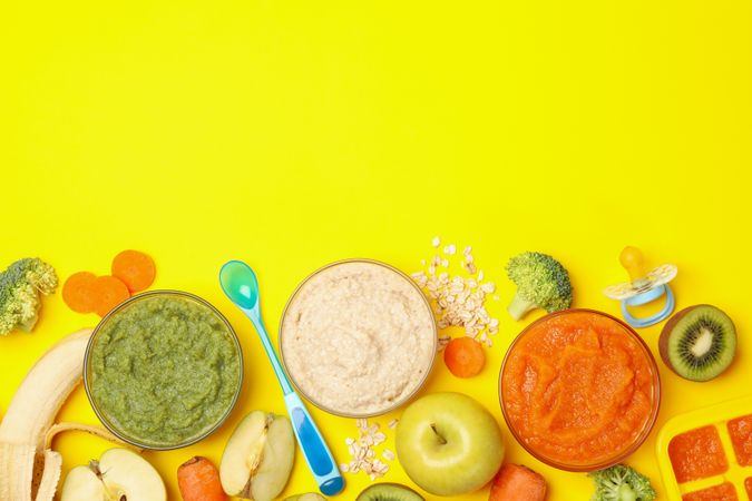 Composition with baby food on yellow background, top view