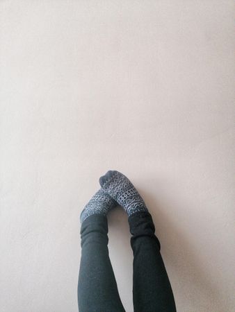 Two feet in gray socks on the wall