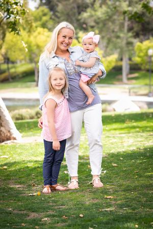 Happy Mommy and Daughters Portrait In The Park