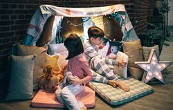 Children preparing tent with chairs and bed sheets