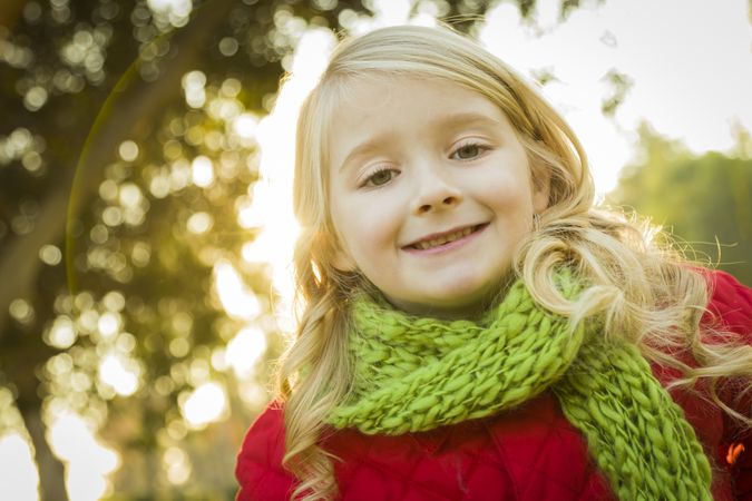 Little Girl Wearing Winter Coat and Scarf at the Park.