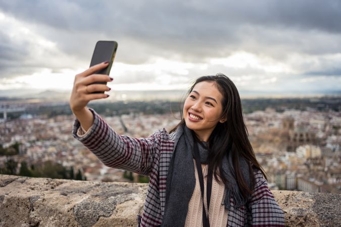 Asian tourist taking selfie against old city