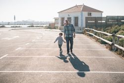 Man with boy walking on street