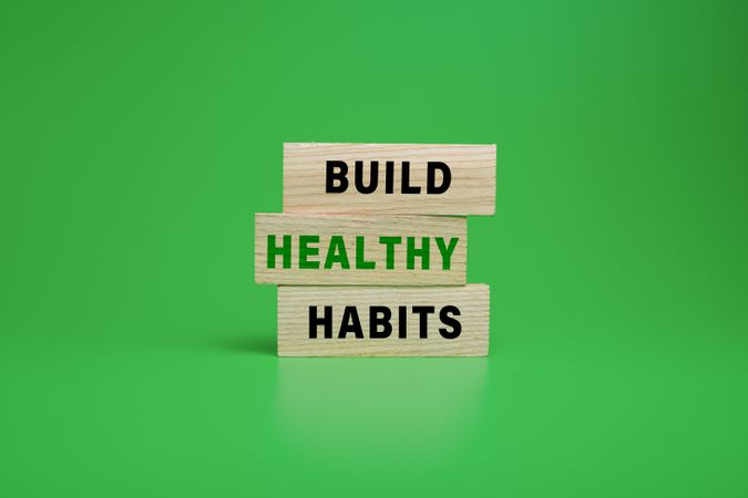 build healthy habits on wooden blocks isolated on green background