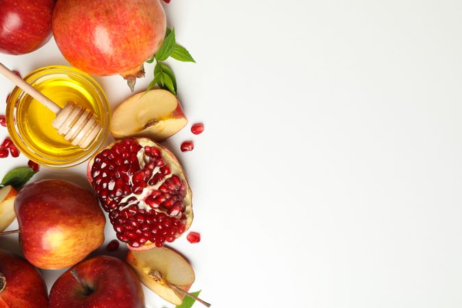 Fresh apple and pomegranate with honey on side with copy space