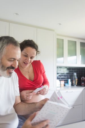 Couple looking through book in kitchen