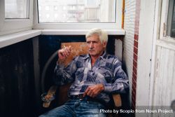 Older man sitting on chair smoking 5oOjk5