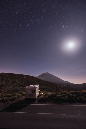 Traveling caravan in desert with bright moon