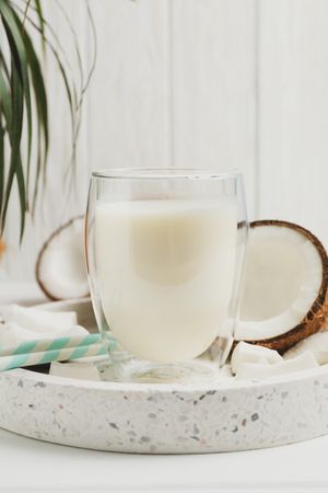 Tray with coconut and milk on wooden background, close up