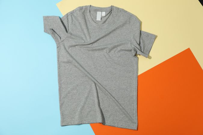 Crumpled gray t-shirt on three tone background, space for text