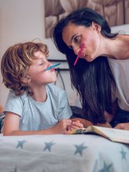 Mother and little son having fun with pencils while drawing
