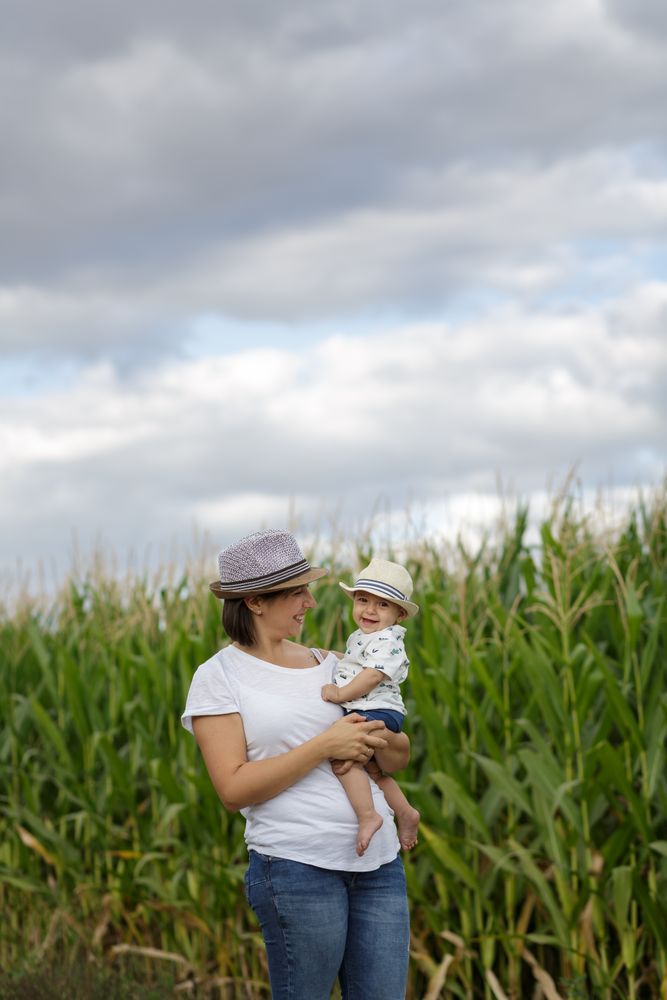 Adorable mother and child on hand enjoying and laughing in field