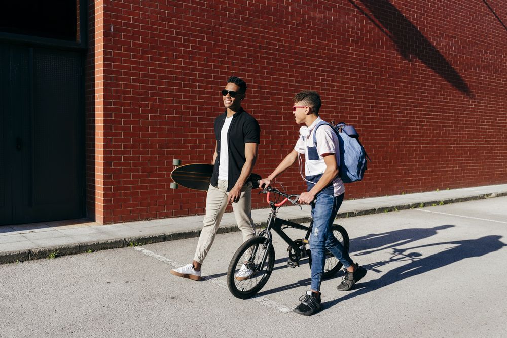 Black cheerful men walking in city