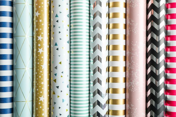 Rolls of festive wrapping paper as background. Top view