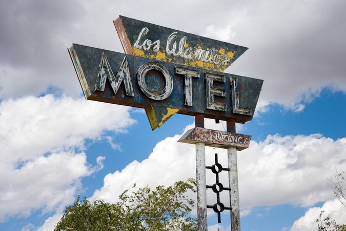 Run down motel sign, against the clouds, Grants, New Mexico