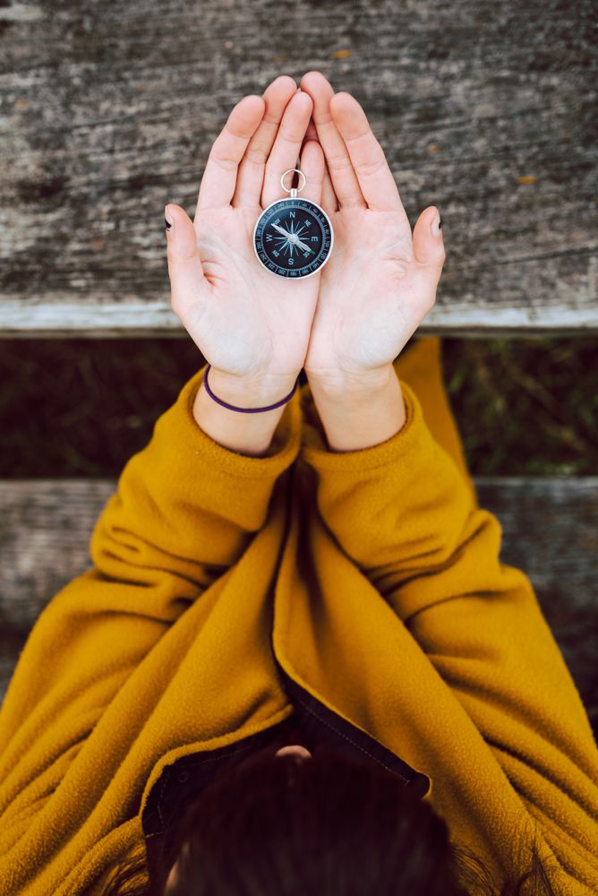 Crop woman with retro compass