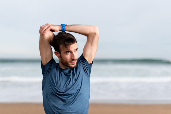 Sportsman warming up to train at beach