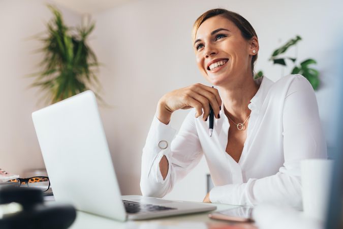 Smiling business woman sitting at her desk in office
