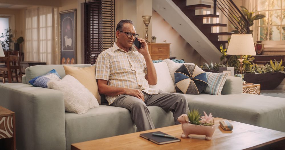 Mature Indian Man Using Smartphone for Call: Cherishing Talks with Loved Ones, Engaging in Meaningful Conversations, and Celebrating Family.