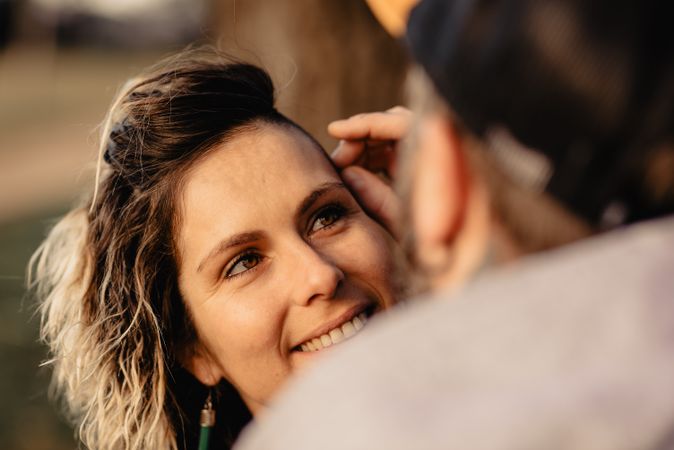 Happy couple hugging near tree in park