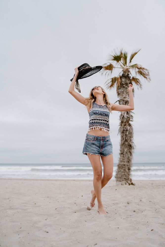 Young female relaxing on beach with hat