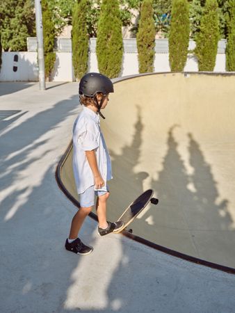 Boy with longboard on ramp edge