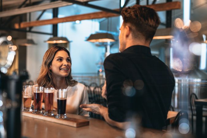 Happy couple having fun while drinking together at bar