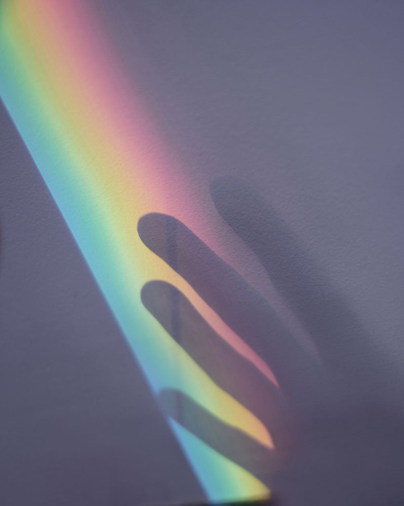 Rainbow and hand shadow on wall