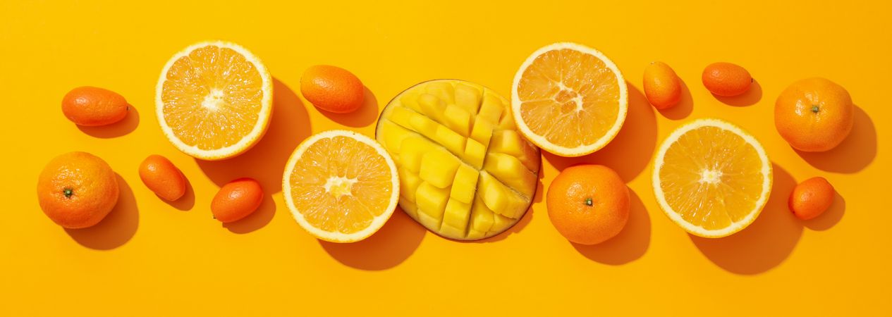 Set of tropical fruit on yellow background, top view