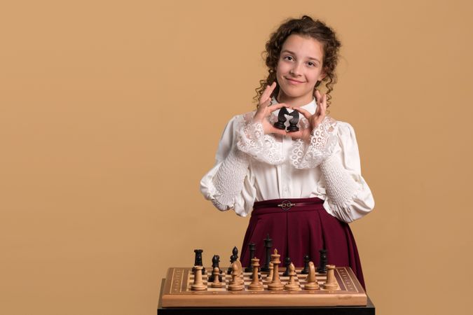 Young girl holding two chess knights