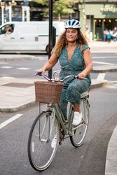 Happy Black woman riding in bike lane on city streets 4Oeyj0