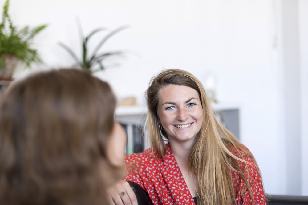Two women friends chatting on the couch at home