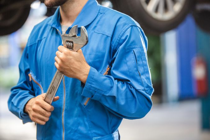 Mechanic man holding wrench equipment tool in auto repair garage