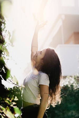 Cheerful woman waving hand in garden
