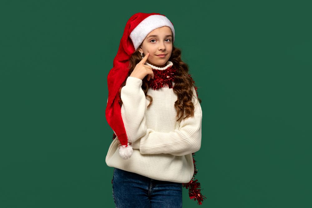 Girl in Santa hat thinking while posing for Christmas.