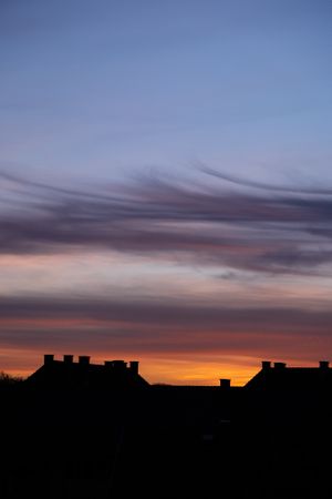 Colorful sky over French village at dawn, vertical